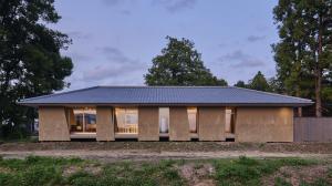 Earthen-walled auberge Ne with a tiled roof glowing at dusk in Shibata, Niigata