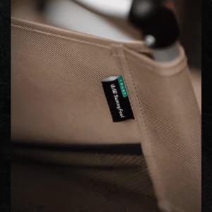 Close-up of the SunnyFeel brand label stitched on the beige fabric of an outdoor folding chair