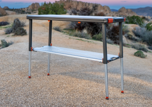 Rocklands Core Station portable aluminum field workstation with patented lower shelf deployed outdoors. A premium quality camping table.