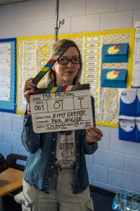 Director Kitty Harper holding clapper board on the set of filming Ma Prison