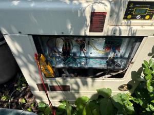 Technician diagnosing a pool heat pump control board on a Long Island service call