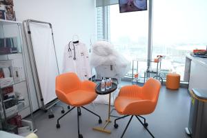 Modern hair transplant consultation room with medical equipment and seating for patient assessments in Dubai.