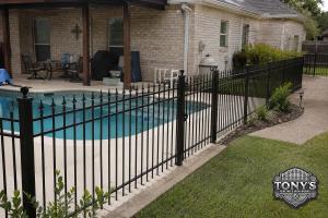 Black ornamental iron pool fence beside a residential swimming pool in Southeast Louisiana