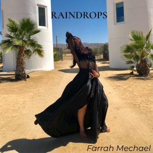Cover artwork for Farrah Mechael's album “Raindrops”, featuring the artist in a flowing black dress between two white towers in a desert landscape