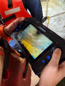 An operator uses a CHASING remote controller to monitor live underwater footage during a pile inspection in Venezuela’s Caroní River.