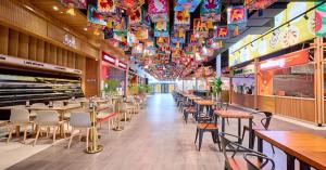 Interior of a completed Greater Vancouver food hall with restaurant counters, seating, and colourful ceiling panels.