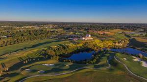 An aerial view of The Club at Iron Lake in Ocala, Florida, showing the championship golf course, clubhouse, limestone quarry landscape, lakes and surrounding grounds at IronCrest, a master planned gated lifestyle community.
