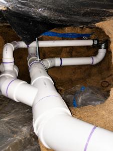 New PVC sewer and drain piping installed beneath a home in a crawl space during a residential sewer line repair. The professionally installed drain system features properly fitted PVC pipe and fittings designed to improve drainage, prevent leaks, and ensu
