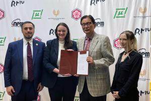 Presidents of USPML, WRC and JPML display signed agreement with interpreter.