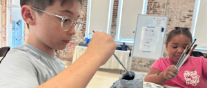 A young boy and a young girl painting.