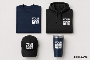 Custom branded navy t-shirt, black hoodie, black cap and navy tumbler from Arklavo, each printed with a white Your Logo Here placeholder on a light background.