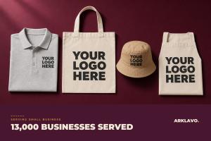Flat lay of custom branded apparel from Arklavo, a polo, tote bag, bucket hat and apron, each printed with a bold Your Logo Here placeholder, beside a 13,000 Businesses Served banner.