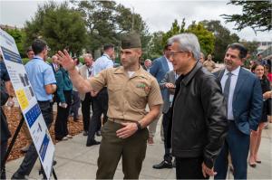 U.S. Marine Corps Maj. Robert Fusco, a Naval Postgraduate School (NPS) student, briefs Jensen Huang, founder and CEO of NVIDIA, during a research poster session at NPS in Monterey, California, July 22, 2026.