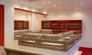 Interior view of MUSASHI JAPAN France Red Store showing illuminated wooden display cases and red knife display cabinets.