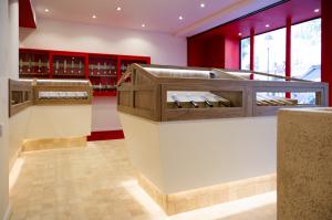 Japanese kitchen knives displayed in wooden glass cases inside the red-themed Paris store.