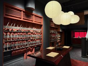 MUSASHI JAPAN Kyoto store interior with Japanese kitchen knives displayed on red shelving and paper lanterns above.
