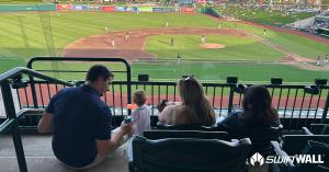A swiftwall family with a newborn at a baseball game enjoying the game