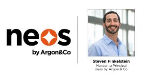 Man smiling at camera and has a beard and mustache with a blue shirt on with neos by Argon & Co