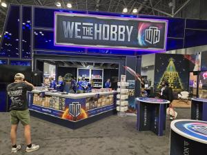 A man taking a photograph of the retail store section of We the Hobby's exhibit