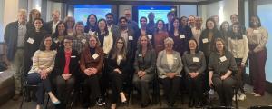 Attendees at the February 2026 Beyond Celiac Coalition-FDA meeting sit in rows and smile at the camera in a conference room.