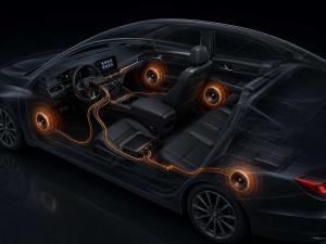 Cutaway view of a car showing an OEM audio upgrade system with factory head unit, plug-and-play T-harness wiring, amplifier and speakers in the doors and rear cabin.