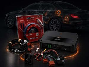Mercedes OEM audio upgrade kit with Hertz amplifier, vehicle-specific T-harness, power cable set and plug-and-play wiring adapters in front of a vehicle cutaway.