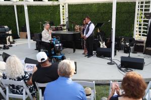 High Hopes student Ron shares how the program helped restore his health during the Eric Marienthal & Friends benefit concert as emcees Mark Desmond and Talaya Trigueros look on.