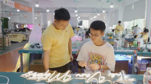 LC Sign employee mentoring students during LED signage production training, demonstrating workplace learning and manufacturing skills development.