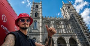 Coffee Bike World founder Vladislav Priadko beside the red Coffee Bike in front of Notre-Dame Basilica in Montreal during THE CROSSING journey.