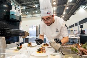 Student Chef Jack Courtney saucing a dish in the ACF Student Chef of the Year competition