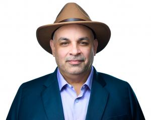 Portrait photo of Jonathane Ricci, founder of JR Wealth Management, wearing a hat and navy blazer.