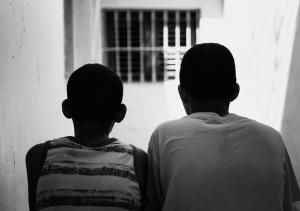 Two boys sitting side by side looking ahead