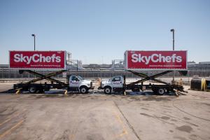 Two Skychefs airline catering trucks sit parked facing each other at San Francisco International airport.