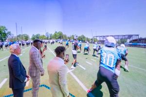 Former Panthers players "call the play" in the huddle as part of The Immersive Cube® experience at the Bank of American Stadium Experience Center opening.