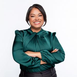 Shannon Fernando-Rubera stands with arms crossed wearing a green top
