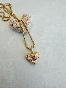 The Coral Rose Heart Charm is shown alongside the naturally heart-shaped piece of coral that inspired its design.