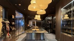 Interior of MUSASHI JAPAN Shibuya Center-Gai Store with Japanese kitchen knives displayed along the wall and warm lantern lighting