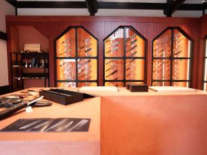 Retail display area at MUSASHI JAPAN Kanazawa Higashi Chaya Store with Japanese kitchen knives and warm red-brown interior design