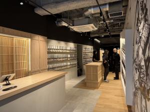Interior of MUSASHI JAPAN Shibuya Main Store with Japanese kitchen knife displays, wooden counters, and sumi-e-style wall artwork