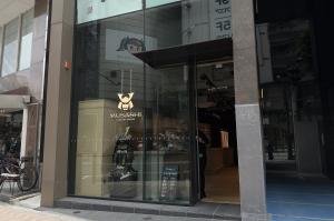 Exterior view of MUSASHI JAPAN Shibuya Main Store in Tokyo with glass storefront, logo, and samurai armor display