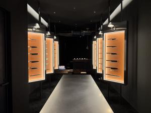 Gallery-style display area inside MUSASHI JAPAN Shibuya Main Store with illuminated Japanese kitchen knife cases