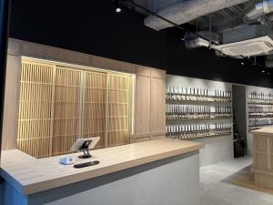 Interior of MUSASHI JAPAN Shibuya Main Store with wooden lattice design, knife wall displays, and modern exposed ceiling