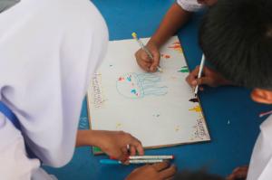 Students at Baan Bangtao School drawing marine animals during the Trash to Treasure environmental education workshop.