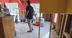 Dr. Dwight Bailey stands inside a flood-damaged Chula Vista home.