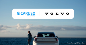 Co-branded key visual showing the CARUSO Dataplace and Volvo logos above a white Volvo electric SUV by the sea, with a woman beside it.