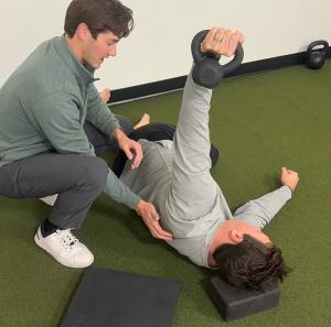 Dr. Taylor helping a patient perform advanced movements to improve their muscles.