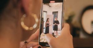 An audience member with golden earrings taking a video of Dr. Weston and Colleen Bush, RDN, while they're on stage, speaking at an event.