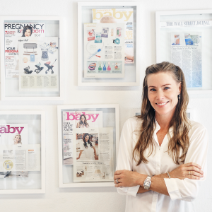Kaisa Levine stands in front of press clippings about Fridababy at her office