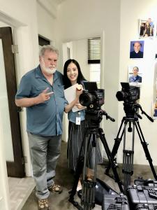 Jieying “Jenny” Liu standing with cinematographer Dean Cundey beside professional film cameras at The Lot Studios in Hollywood.