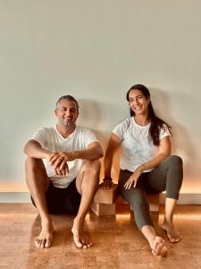 Frankie and Yasmine Zaccanelli, co-founders of Atelier Yoga, sitting on cork yoga blocks on the studio's cork floor in Dallas, Texas.